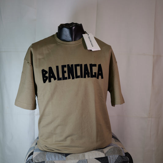 Beige t-shirt with 'BALENCIAGA' branding on a mannequin against a plain background